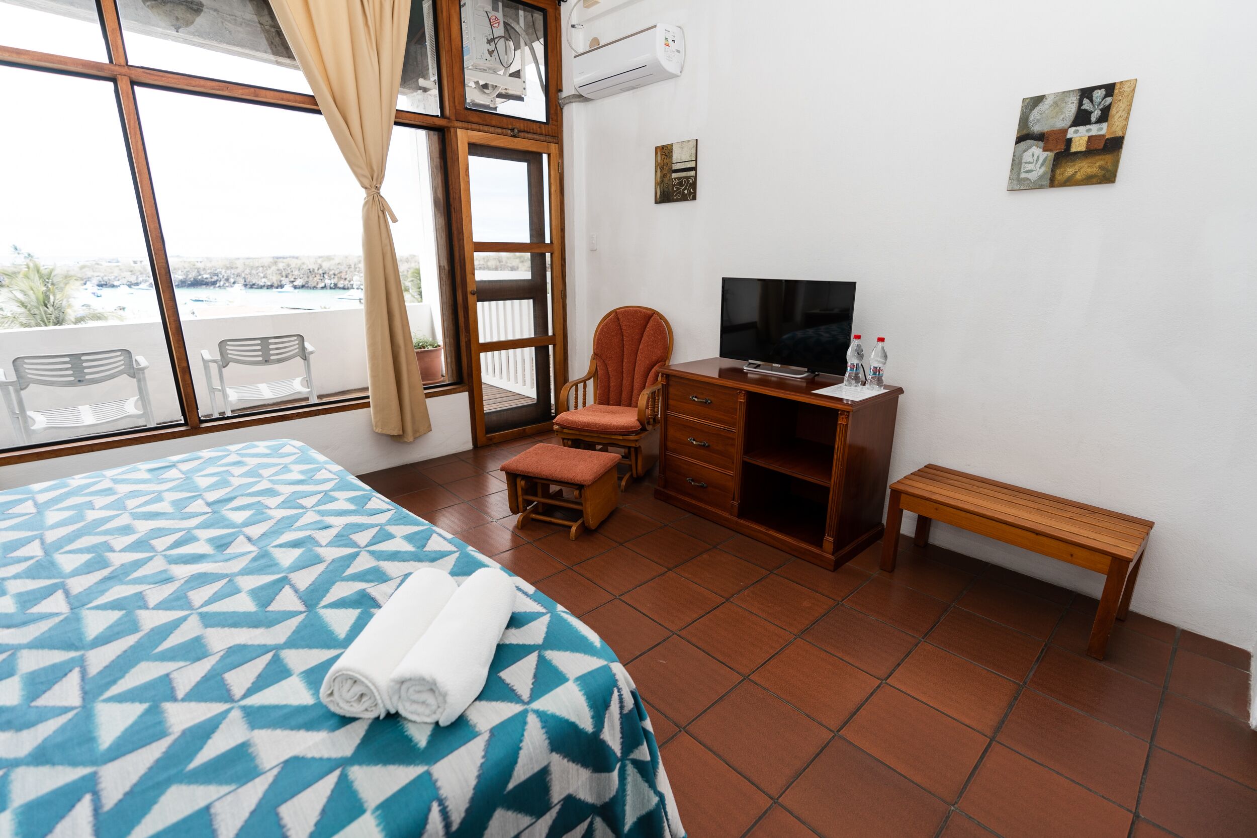 Une chambre d’hôtel avec un lit, un bureau, une télévision et une fenêtre donnant sur un paysage agréable.