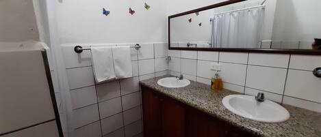 A bathroom with two sinks, a mirror, and a towel rack.