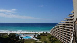 Een hoog hotel met zwembad en uitzicht op het strand.