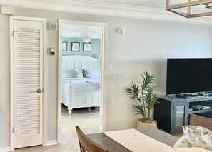 Une chambre à coucher avec un lit, un ventilateur de plafond et un téléviseur.