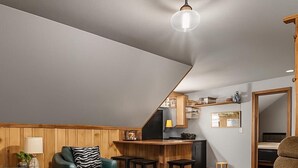 A loft-style room with a kitchen, bar area, and seating.