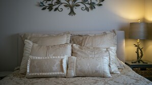 A neatly made bed with a decorative wall piece above it.