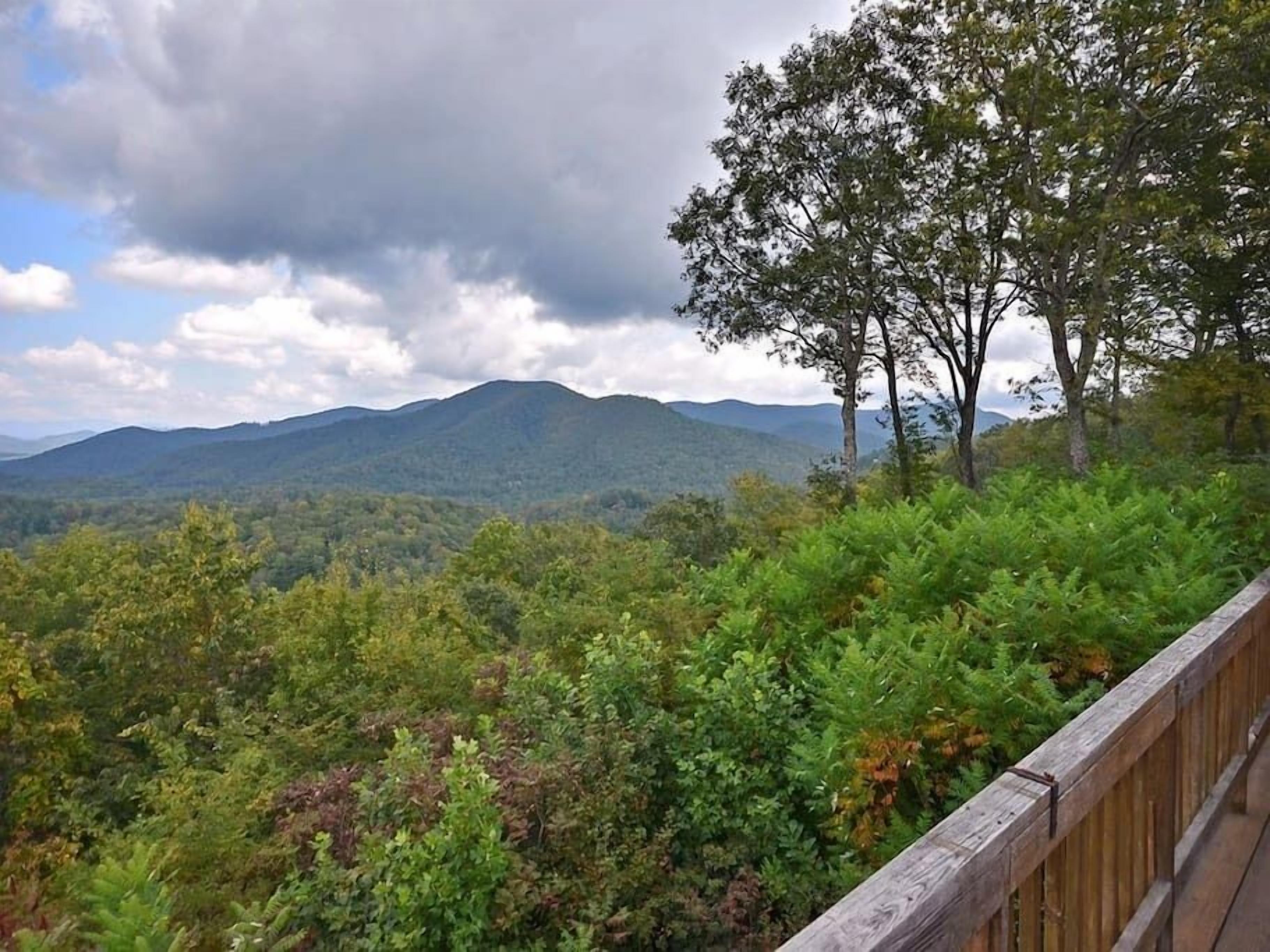 A forested mountain landscape with a wooden viewing platform.