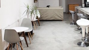 Un espacio habitable moderno y minimalista, con comedor, sofá y televisor montado en la pared.