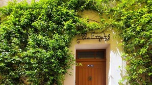 A building entrance with a wooden door, a sign above the door, and greenery on the walls. - Great brand new 1 bedroom apartment in the center of old Antibes (Antibes)