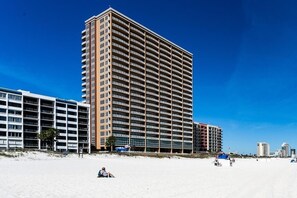 Un hotel de gran altura con varios pisos, techo plano y vista al mar.
