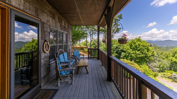 A wooden deck with outdoor seating, a view of the mountains, and a hanging flower basket. - Chipmunk View Lodge - Amazing views, hot tub, and manmade waterfall! (Blowing Rock)