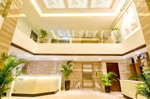 A hotel lobby with a reception desk, two elevators, and decorative potted plants. - Commander Suites de Boracay (Boracay Island)