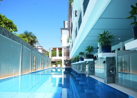 Una piscina al aire libre, sillones reclinables de piscina