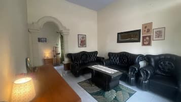 A living room with a sofa set, a coffee table, and a lamp.