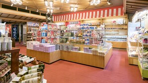 A well-lit store with various products on shelves and counters, including boxes and bottles. - Isawa Tokiwa Hotel (Fuefuki)