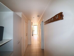 Leading to a bright room, this hallway features a door and a decorative sign.