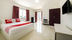 Ein Hotelzimmer mit Bett, Schreibtisch, Kleiderschrank und Fernseher.