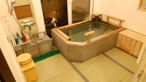 A traditional Japanese onsen with a wooden bench, a glass-enclosed hot spring, and a small wooden table. - Tenshi no Iruka (Ito)