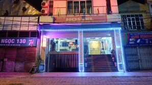 Un edificio de varios pisos con un hostal en la planta baja, que incluye una escalera y una recepción.
