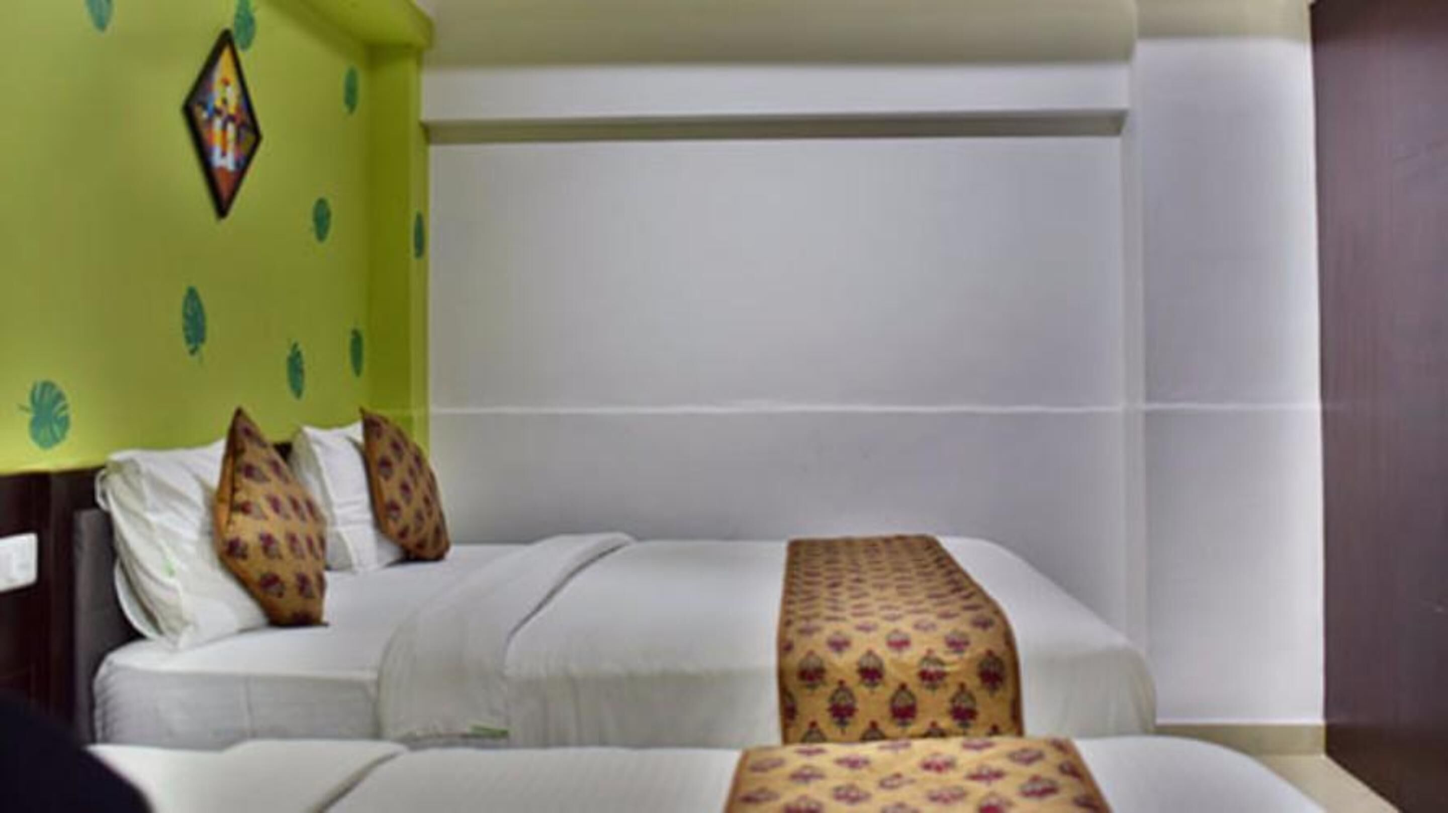 A hotel room with a bed, pillows, and a wall with a geometric pattern.