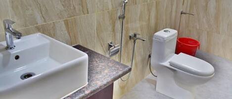 Un baño con lavamanos blanco, inodoro y ducha.
