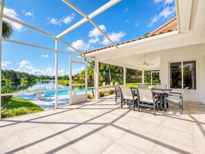 A covered patio with a view of a lake, outdoor furniture, and a swimming pool. - SWISS 66 - Lake Denise (Clermont)