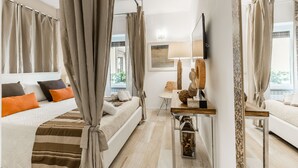 A modern hotel room with a large bed, a bedside table, a mirror, and a view of the outdoors. - The Best in Rome Vite (Rome)
