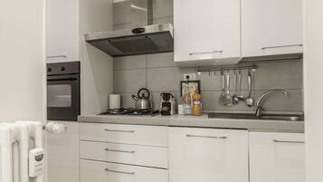 Apartamento, 3 quartos | Cozinha privada | Geladeira grande, micro-ondas, fogão, cooktop