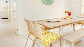 Un espace repas comprenant une table en bois, des chaises et des bancs.