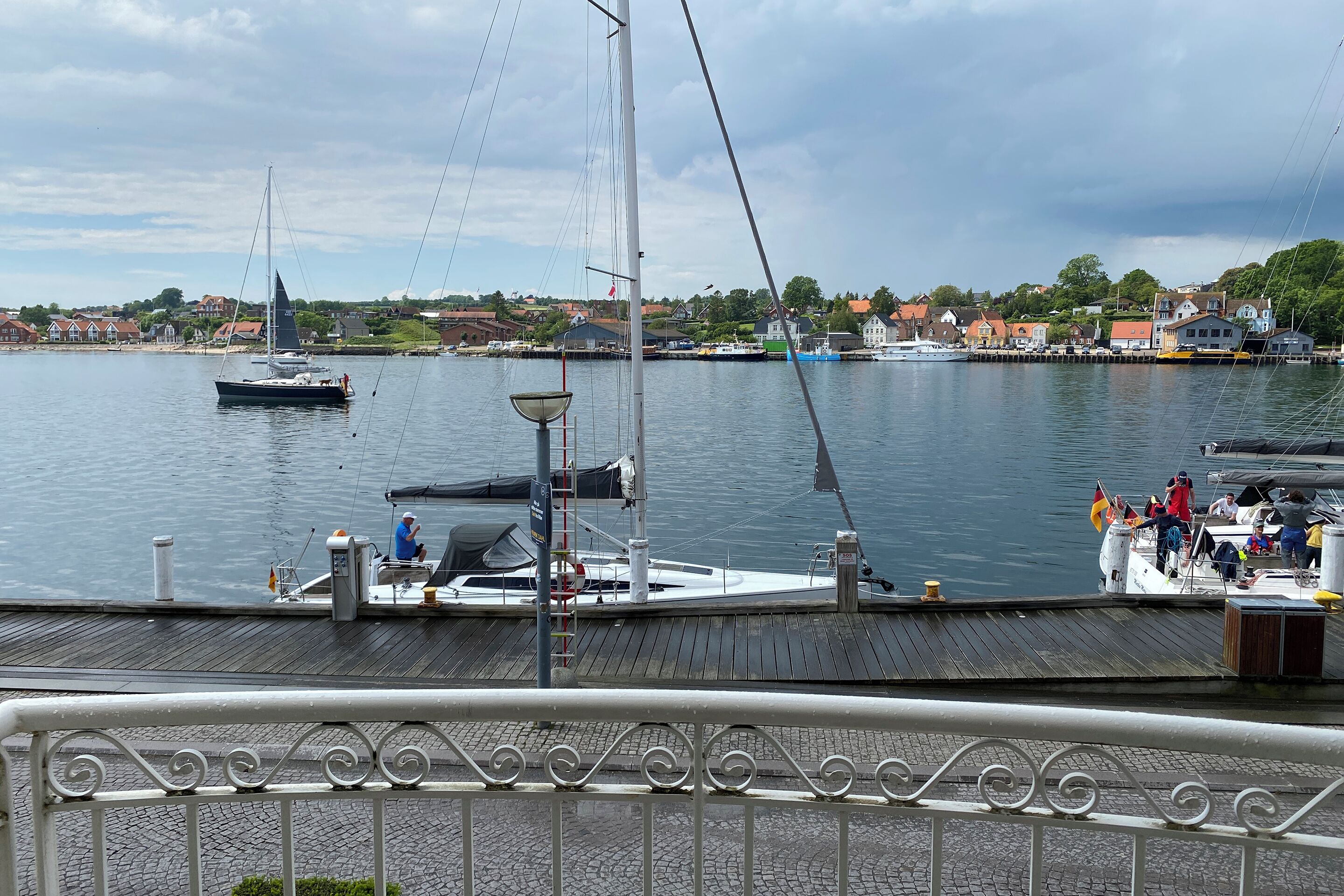A harbor with boats, a dock, and a town in the background.