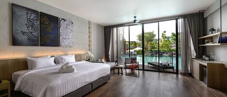 Una habitación de hotel moderna con una cama grande, vista a una piscina y un balcón.