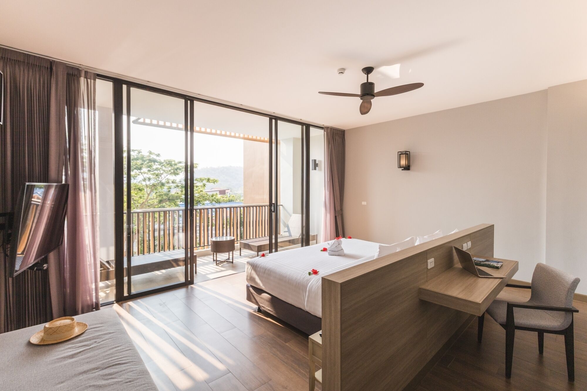 Una habitación de hotel moderna con balcón, cama, escritorio y silla.