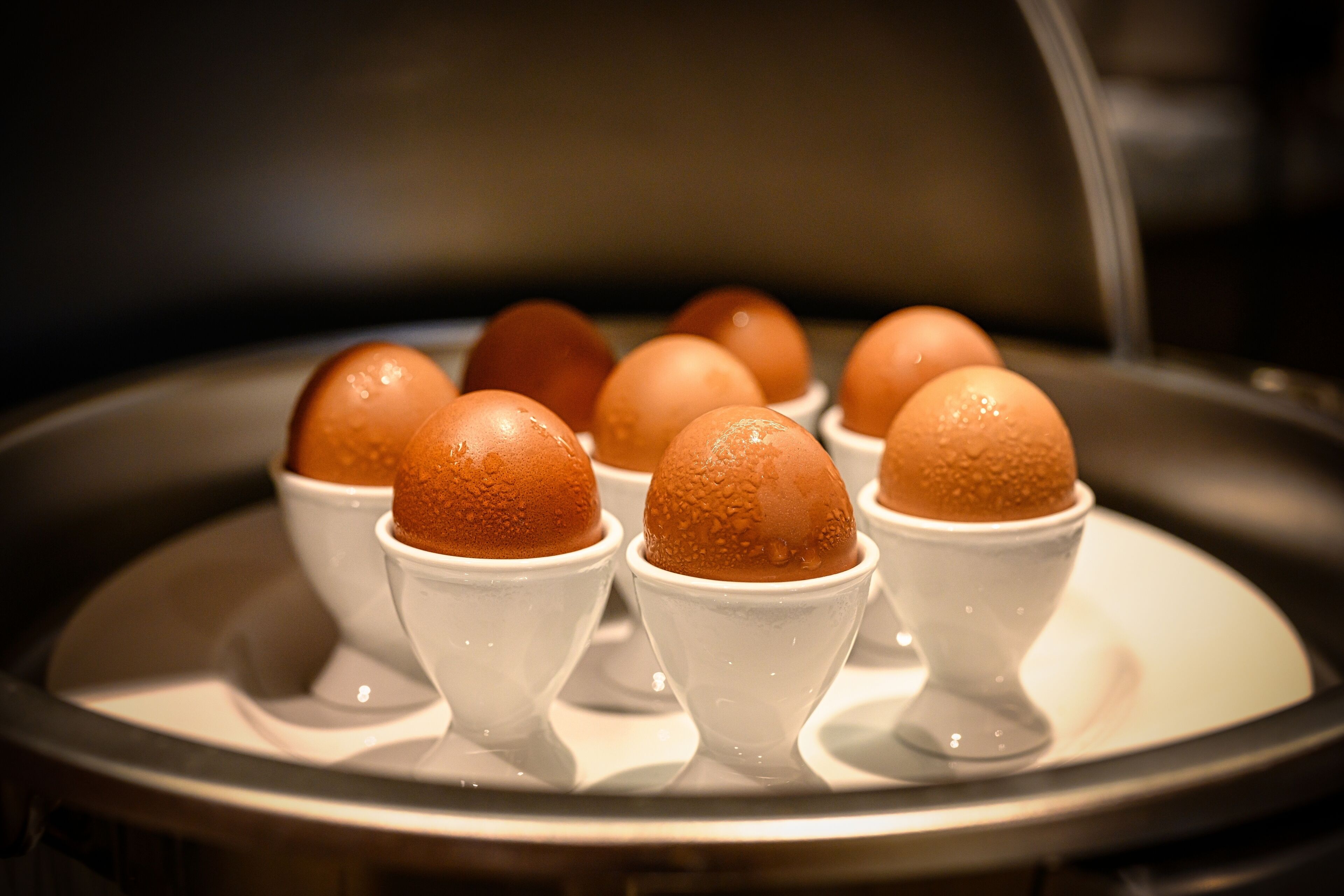 A tray of eggs in individual cups.