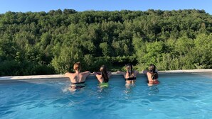 Une piscine où trois personnes se détendent.