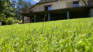 Une maison avec un toit en pente, deux fenêtres apparentes et une véranda couverte.