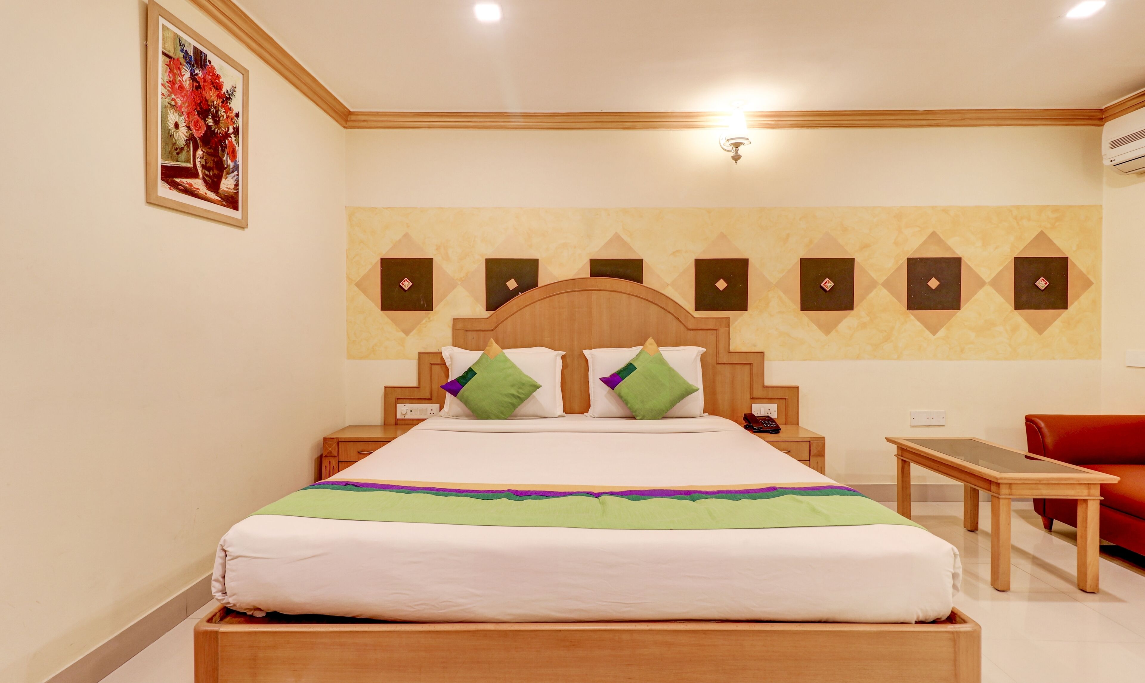 Una habitación de hotel con cama, mesita de noche y una silla.