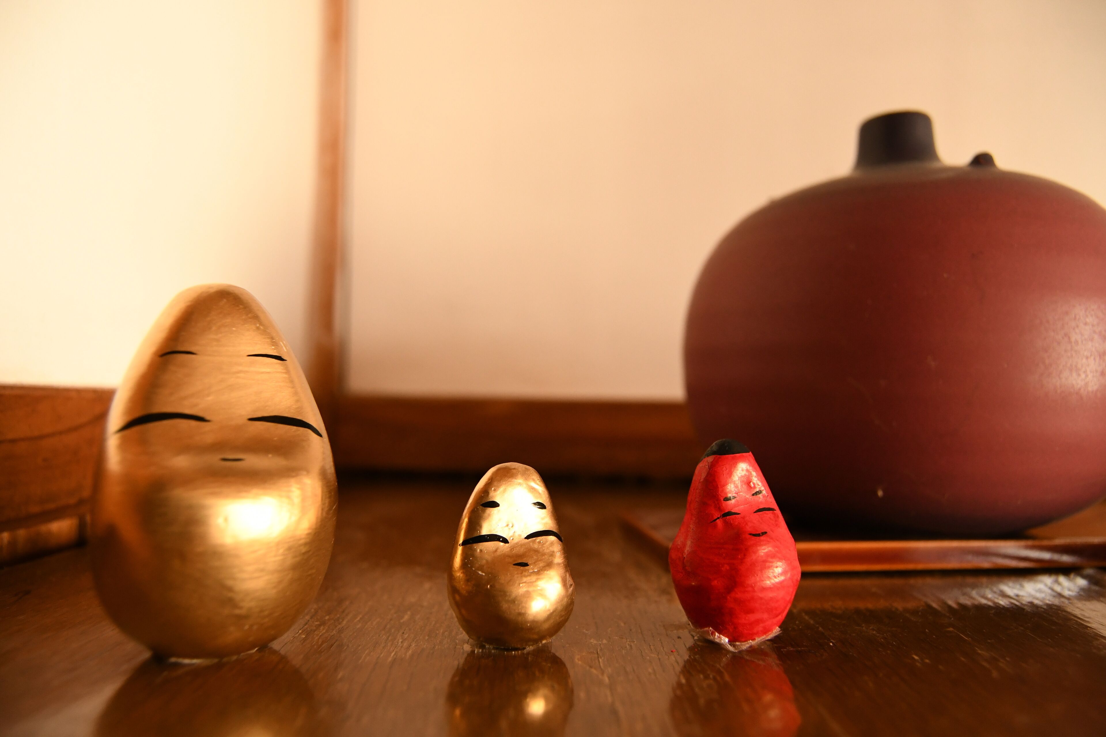 Three wooden figures on a wooden surface.
