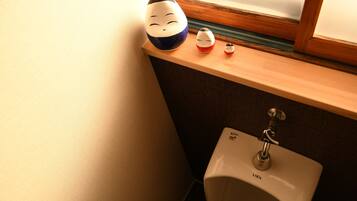 A bathroom with a sink, a window, and a shelf with decorative items.