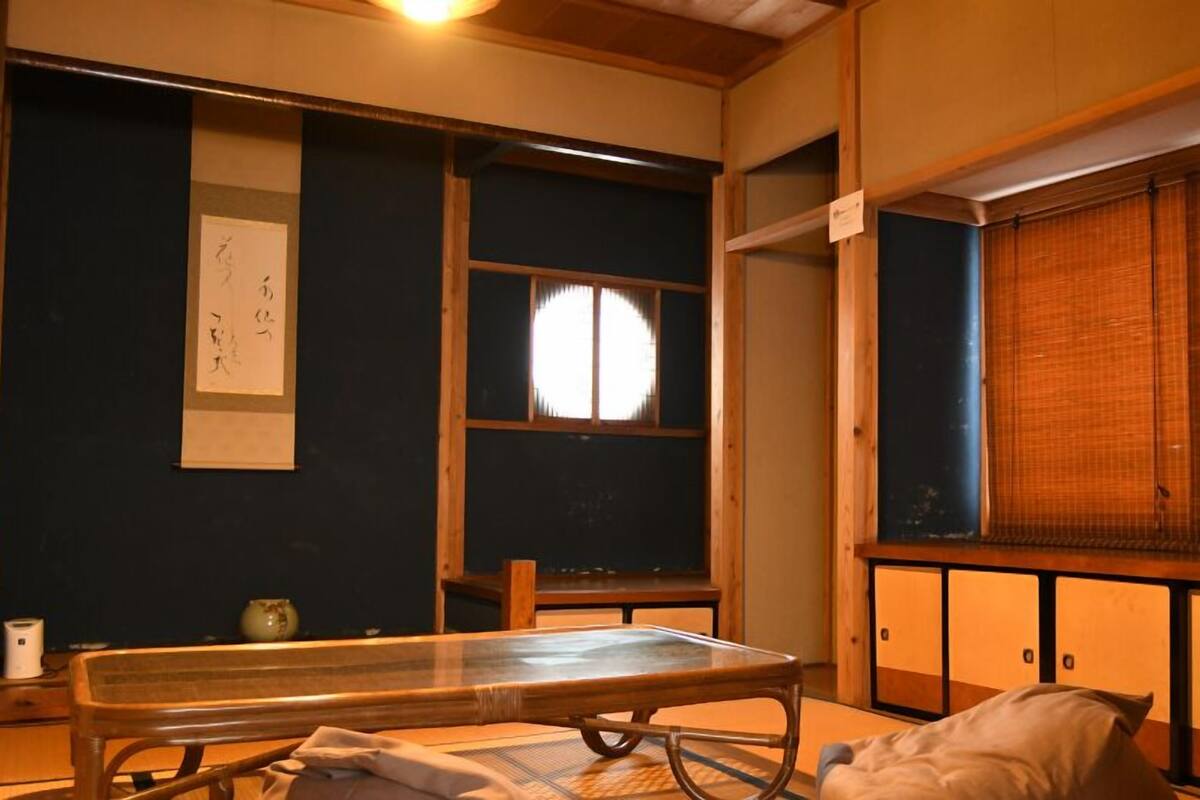 A traditional Japanese room with tatami flooring, a low table, and sliding doors.