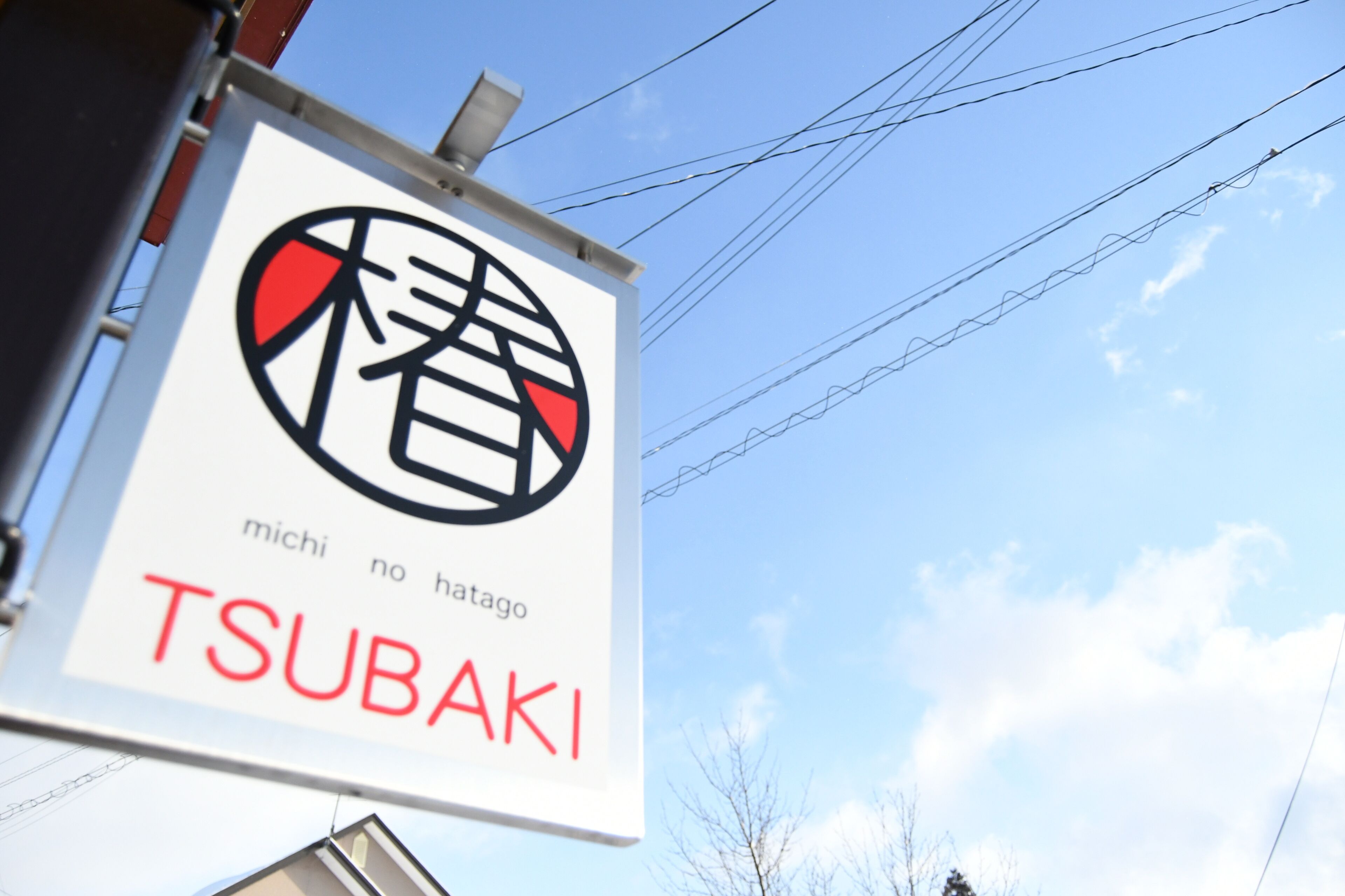 A sign with Japanese characters and the name "TSUBAKI".
