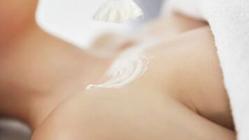 A close-up of a person's skin with a white cream applied.