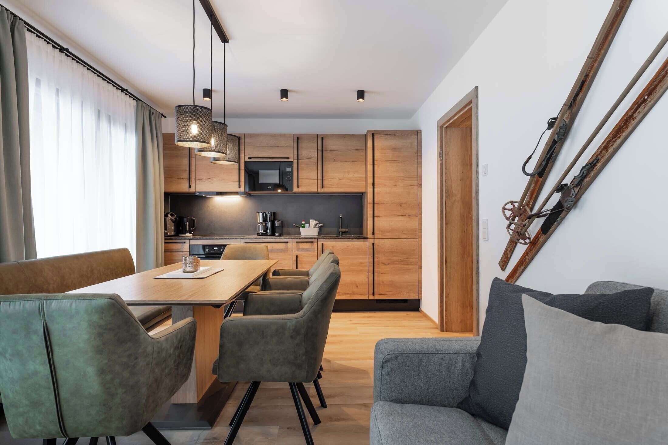 Une cuisine moderne avec des meubles en bois, une table à manger avec des chaises et un canapé.