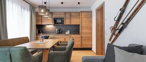 Une cuisine moderne avec des meubles en bois, une table à manger avec des chaises et un canapé.