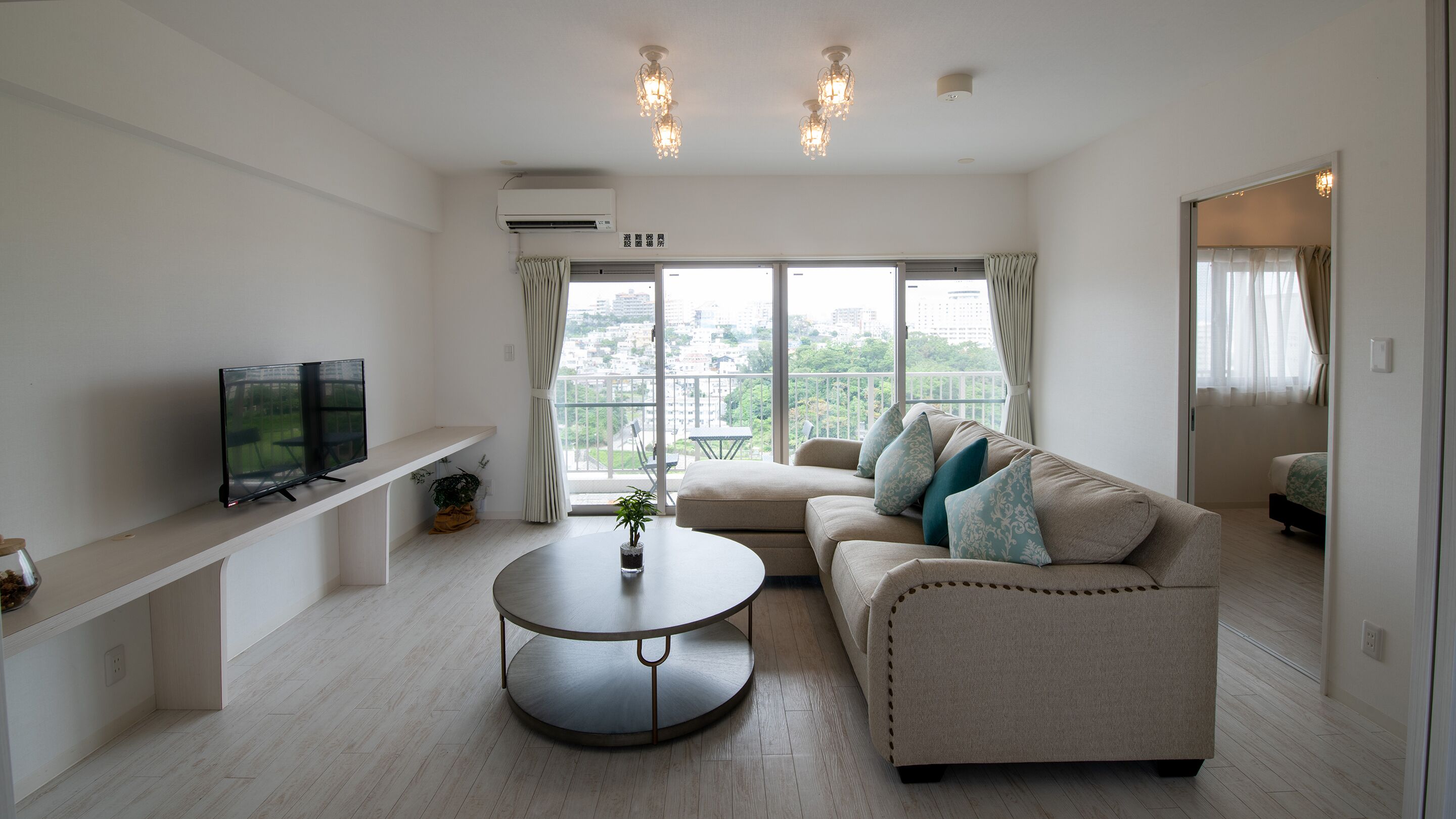 A modern living room with a sofa, a coffee table, and a TV on a stand.