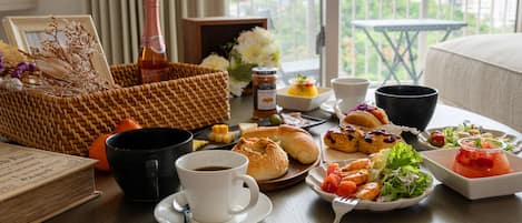 A breakfast setting with a variety of foods, drinks, and a wicker basket.