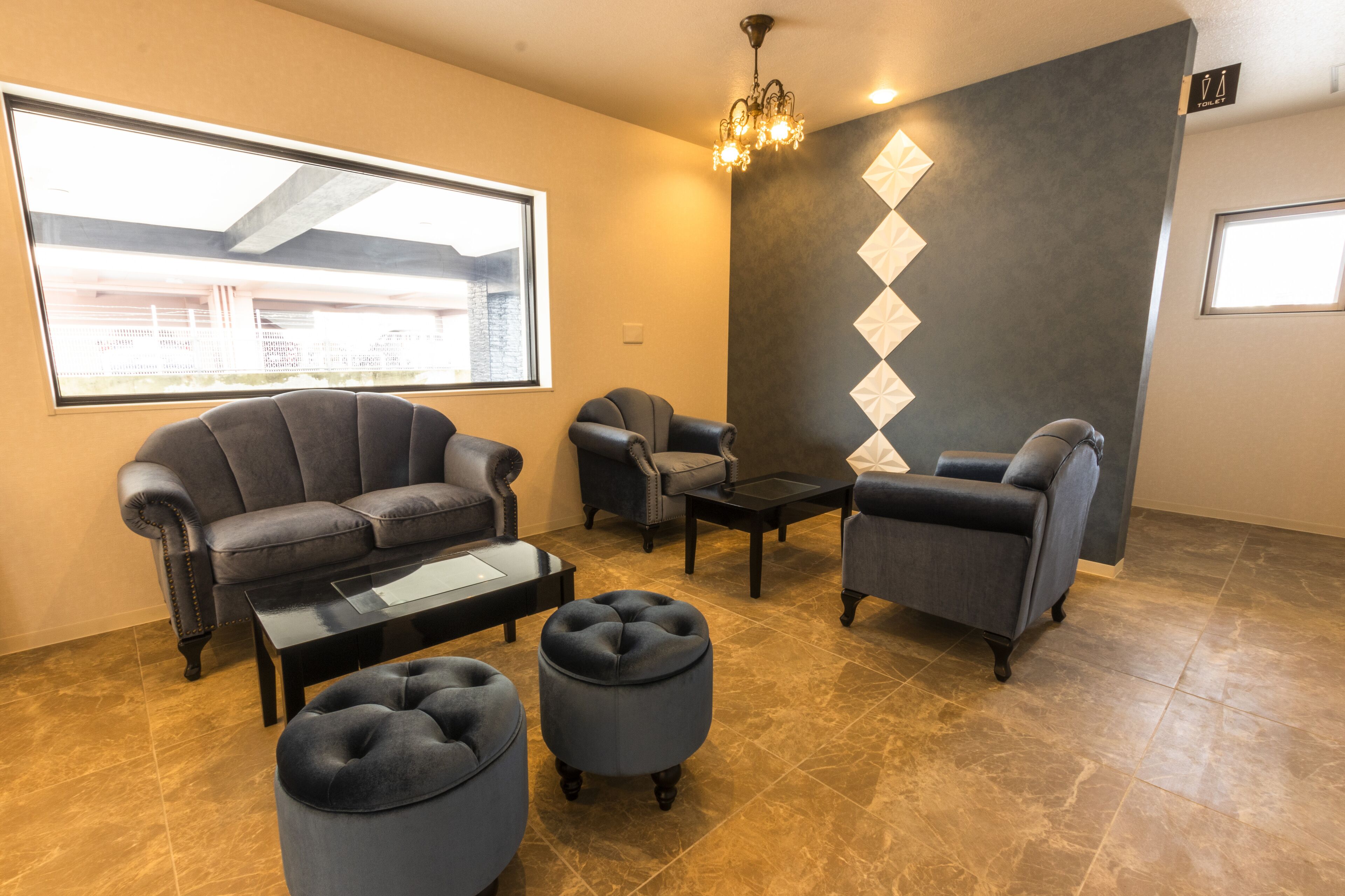 A modern living room with a sofa, armchairs, ottoman, and a coffee table.