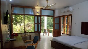 A room with a bed, a desk, a chair, and large windows. - Balishira Resort (Kamalganj)