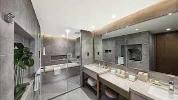 A modern bathroom with a glass-enclosed shower, two sinks, and a large mirror.