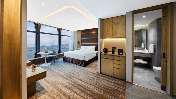 A modern hotel room with a large bed, a desk, a small table, and a bathroom. - Oasis Aurum 181 Hotel (Hong Kong)