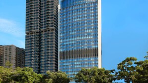 A high-rise building with a modern glass facade and a curved top. - Oasis Aurum 181 Hotel (Hong Kong)
