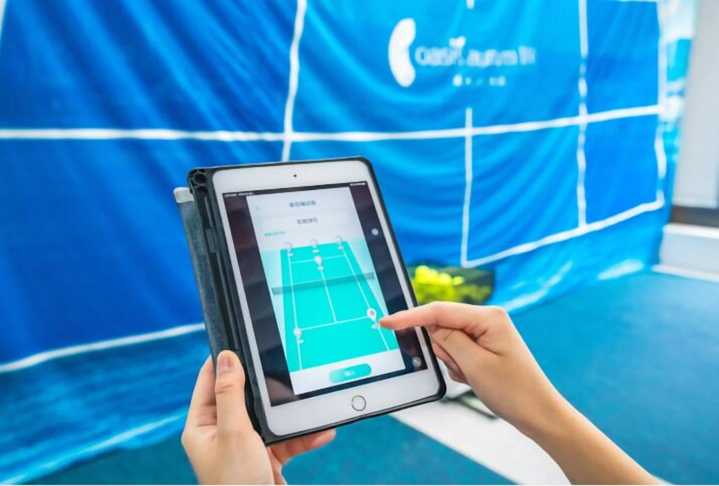 Una persona sostiene una tableta que muestra el plano de una cancha de tenis.