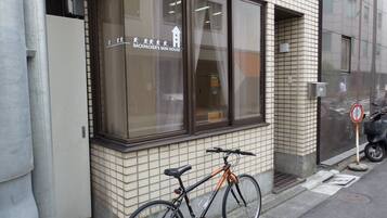 Un edificio con un letrero que dice "BACKPACKER'S MINI HOUSE" y una bicicleta estacionada afuera.