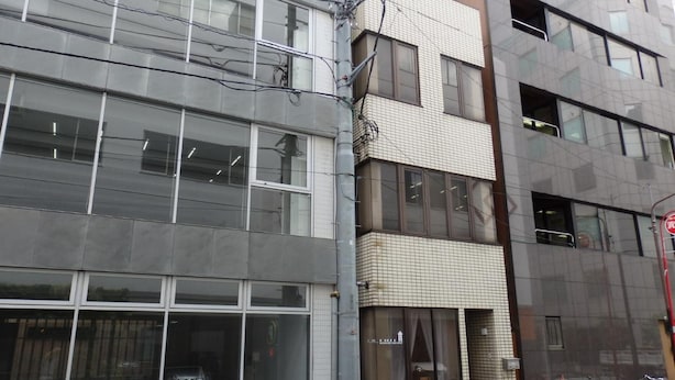 A modern building with large windows and a bicycle parked outside.