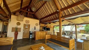 Un intérieur en bois avec un plafond haut, un comptoir d’accueil, un espace salon et une vue sur l’extérieur.